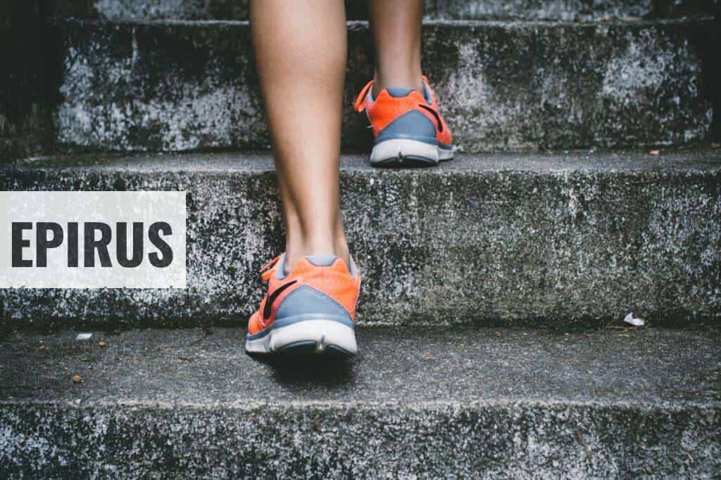 person wearing orange and gray Nike shoes walking on gray concrete stairs