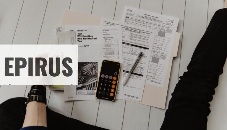 person holding paper near pen and calculator