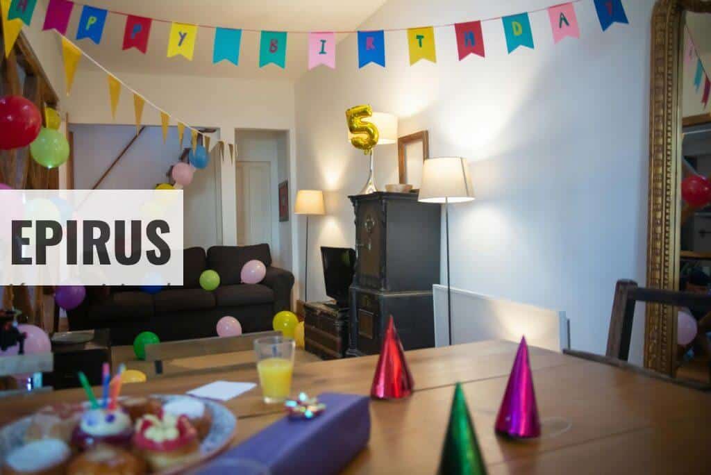 Indoor 5th birthday party setup with balloons, banners, and party hats in a cozy home setting.