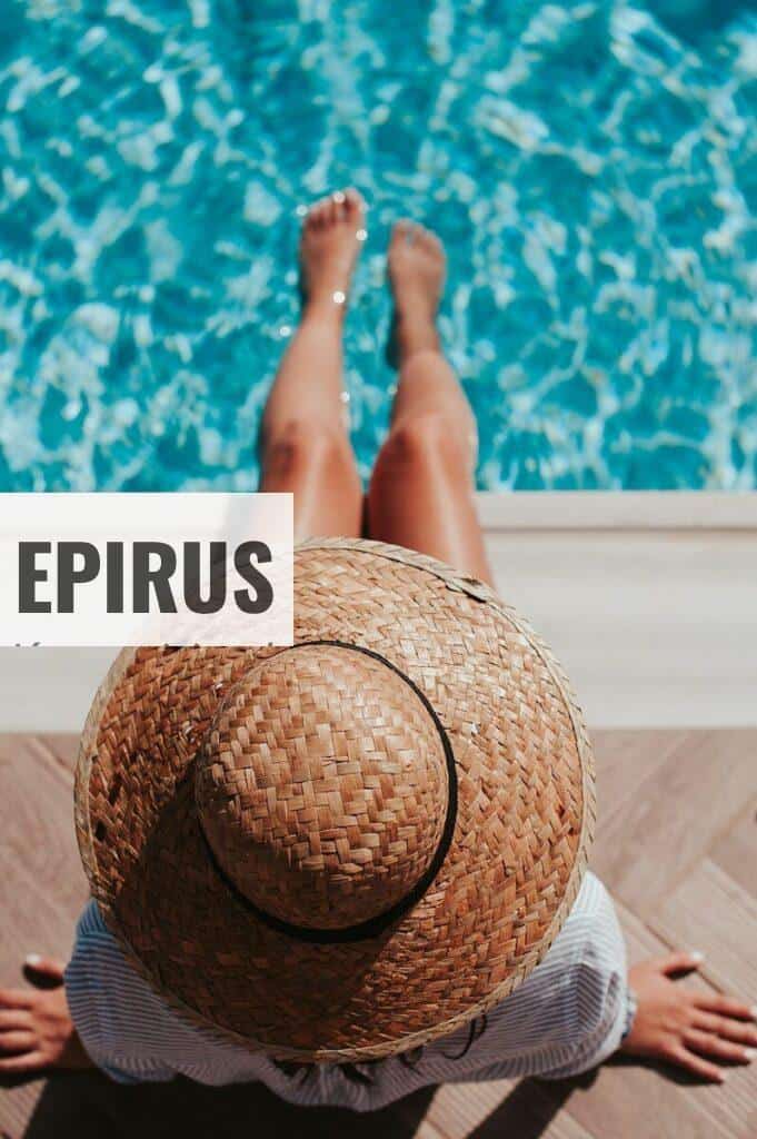 woman sitting on poolside setting both of her feet on pool